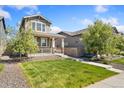 Charming home featuring a covered front porch and well-maintained lawn at 15957 E Elk Pl, Denver, CO 80239