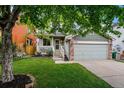 Charming home featuring a well-kept lawn, inviting porch, and two-car garage, perfect for suburban living at 12261 N Holly Way, Brighton, CO 80602