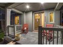 Inviting front porch with rocking chairs, a decorative wreath, and warm lighting, perfect for relaxing outdoors at 8444 E 55Th Pl, Denver, CO 80238