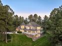 Stunning aerial view of an estate nestled within a dense forest with a manicured lawn at 407 S White Tail Dr, Franktown, CO 80116