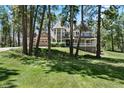 Inviting home surrounded by mature trees and a well-maintained lawn at 407 S White Tail Dr, Franktown, CO 80116