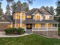 Charming home with a turret, front porch, manicured lawn, and a welcoming entrance at 407 S White Tail Dr, Franktown, CO 80116