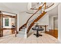 Grand foyer showcases a curved staircase, elegant tile flooring and sophisticated architectural details at 1027 S Fillmore Way, Denver, CO 80209