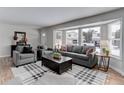 Bright and airy living room with gray furnishings, hardwood floors, and large windows at 8012 S Cedar St, Littleton, CO 80120