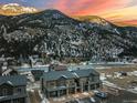 Scenic aerial view of modern townhomes near a river, set against a backdrop of snow-capped mountains at 2115 Hummingbird Way # 105, Georgetown, CO 80444