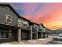 Modern townhome exterior featuring stone pillars, balconies, and scenic mountain backdrop at dusk at 2115 Hummingbird Way # 105, Georgetown, CO 80444