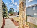 Landscaped front yard view from the porch, showcasing a stone pillar and neighborhood street at 9711 Millstone Ct, Highlands Ranch, CO 80130