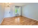 Bright living room featuring hardwood floors, a large window, and a white front door at 10460 Ketchwood Ct, Highlands Ranch, CO 80130