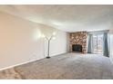 Inviting living room with stone fireplace and sliding glass doors to outdoor space at 865 S Quebec St # 104B, Denver, CO 80247