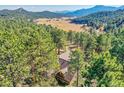 Expansive views surround this secluded home in a lush valley with distant mountains at 24929 N Mountain Park Dr, Evergreen, CO 80439