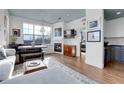 Cozy living space with a fireplace, large windows, and an open layout connecting to the kitchen at 3000 E 16Th Ave # 320, Denver, CO 80206