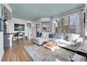 Bright living room featuring a plush sectional, colorful rug, and scenic views from large windows at 3000 E 16Th Ave # 320, Denver, CO 80206