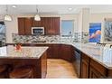 Well-lit kitchen with granite countertops, wooden cabinets, and tile backsplash at 952 Eaglestone Dr, Castle Rock, CO 80104