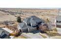An eye-level view of the home with mature trees and a three car garage at 12092 S Great Plain Ct, Parker, CO 80134