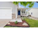 Inviting front porch with a bright blue front door, a well-manicured lawn and flower beds at 9625 Bighorn Way, Littleton, CO 80125