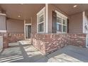 Inviting front porch featuring brick accents and ample natural light at 3391 Prairie Vista Dr, Castle Rock, CO 80109