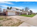 Two-story home with brick accents, a two-car garage, and long concrete driveway at 2940 S Reed St, Denver, CO 80227