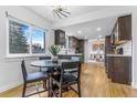 Open-concept kitchen and dining area with modern lighting and hardwood floors at 2940 S Reed St, Denver, CO 80227
