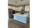 Modern kitchen featuring stainless steel appliances, a center island with seating, and stylish pendant lighting at 251 Washington St, Erie, CO 80516