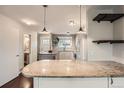 Renovated kitchen with granite countertops, custom island, and stainless steel refrigerator at 6492 Simms St # A, Arvada, CO 80004