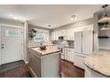 Charming kitchen with white cabinets, a wood-topped island, and a cozy breakfast nook at 6492 Simms St # A, Arvada, CO 80004