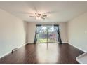 Light-filled living room featuring hardwood floors, ceiling fan, and sliding glass doors to backyard at 6492 Simms St # A, Arvada, CO 80004
