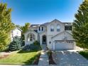 Charming two-story home with a well-manicured lawn, lovely landscaping, and a basketball hoop over the garage at 2880 Breezy Ln, Castle Rock, CO 80109