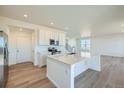Elegant kitchen boasts quartz countertops, a center island, stainless appliances, and hardwood floors. Recessed lighting at 720 N Deer Park St, Watkins, CO 80137
