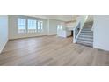 Bright and airy living room features hardwood floors, large windows, and a staircase leading to the upper level at 720 N Deer Park St, Watkins, CO 80137