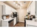 Modern kitchen boasts white cabinets, quartz countertops, and black appliances at 1608 Cottonwood Dr # 4, Louisville, CO 80027
