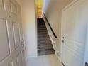 Bright entryway with tile flooring, a coat closet, and a carpeted staircase leading to the upper level at 11983 W Long Cir # 203, Littleton, CO 80127