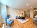 Cozy living room with hardwood floors, a comfortable sofa, and natural light at 6484 S Datura St, Littleton, CO 80120