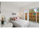 Cozy bedroom with soft pink accents, plush bedding, and access to private outdoor space at 5367 W 14Th Ave, Lakewood, CO 80214