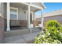 Inviting front porch with a comfortable bench, potted flowers, and classic architectural details at 13644 Ulster St, Thornton, CO 80602