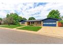 Well maintained brick home with blue trim, mature trees, and an attached two car garage at 353 S Niagara St, Denver, CO 80224