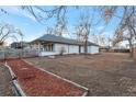 Spacious backyard with a large grassy area and a path leading to the back of the house at 1765 Ingalls St, Lakewood, CO 80214