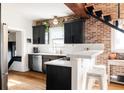 Modern kitchen with black cabinets, stainless steel appliances, and a breakfast bar at 4452 Stuart St, Denver, CO 80212