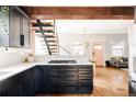 Contemporary kitchen showcasing dark cabinetry, quartz countertops, and hardwood floors at 4452 Stuart St, Denver, CO 80212