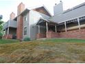 Exterior view of a home featuring gray siding, brick accents, covered entrance and sloped yard at 1405 Broadway St # 302, Boulder, CO 80302