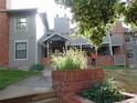 Exterior view of a home featuring gray siding, brick accents, a covered entrance, and landscaping at 1405 Broadway St # 302, Boulder, CO 80302