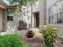 Charming home entrance with manicured landscaping, outdoor seating, and a tiered fountain at 9266 E 35Th Ave, Denver, CO 80238