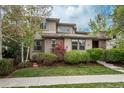 Charming stucco home featuring a landscaped front yard with mature trees and lush green lawn at 9266 E 35Th Ave, Denver, CO 80238