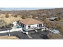 Stunning aerial view of a modern home, showcasing its multiple decks, pool, and meticulously landscaped grounds at 1140 Lake Gulch Rd, Castle Rock, CO 80104