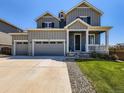 Inviting two-story home featuring a three-car garage, manicured lawn, and charming covered porch at 10 N Quantock St, Aurora, CO 80018
