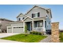 Charming two-story home featuring a welcoming front porch and manicured lawn at 10 N Quantock St, Aurora, CO 80018