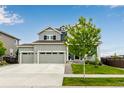 Inviting home featuring a three-car garage, blue accents, and a well-kept lawn at 10 N Quantock St, Aurora, CO 80018