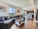 Spacious living room showcasing an open floor plan, hardwood floors, and large windows offering ample natural light at 10 N Quantock St, Aurora, CO 80018