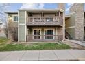 This exterior view shows two-story condos with wooden decks, patios, and well-maintained landscaping at 3400 S Eagle St # 104, Aurora, CO 80014