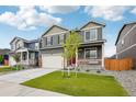 The two-story home has complementary landscaping, a covered porch, and a well-maintained lawn at 715 N Amory St, Watkins, CO 80137