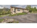 Quaint home featuring gravel driveway and lush surrounding nature at 30839 Manitoba Dr, Evergreen, CO 80439